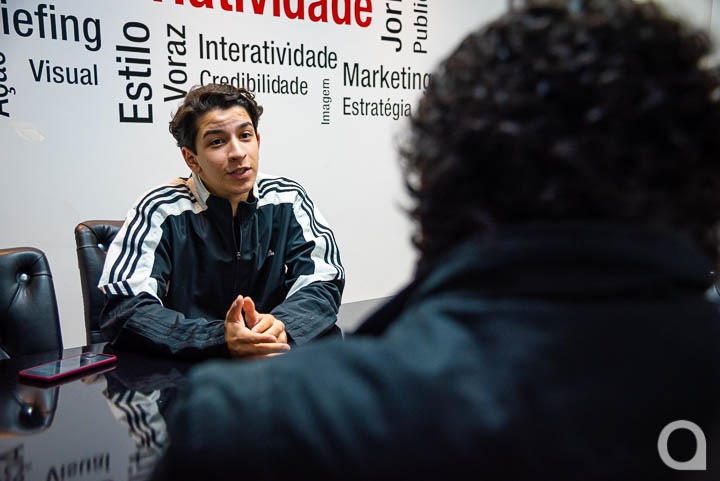 O jovem prodígio Davi Jardim Guidelli sentado dando entrevista para um repórter do OBemdito. O repórter aparede de costas
